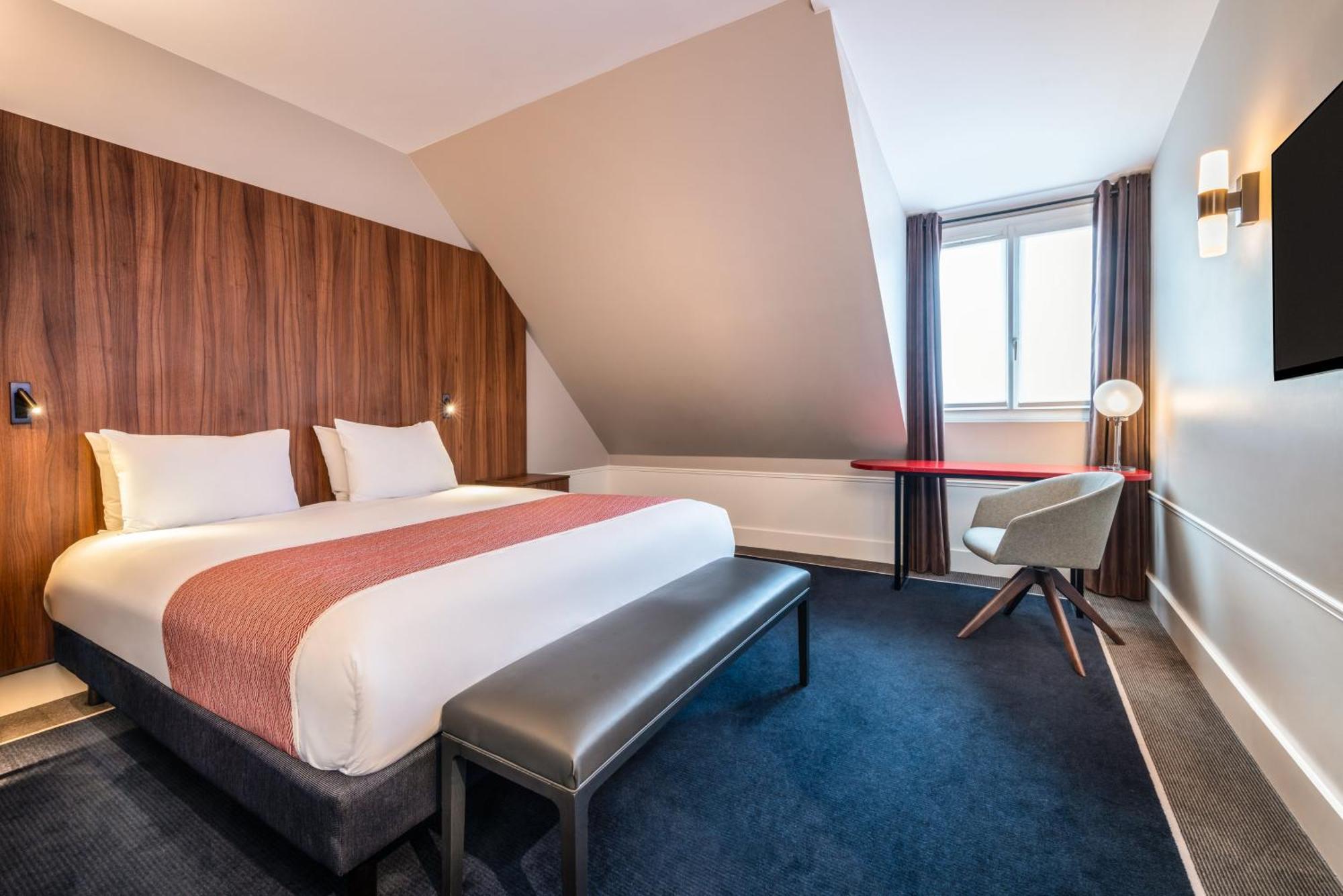 Suite con cama extragrande, sofá cama y vistas a la ciudad