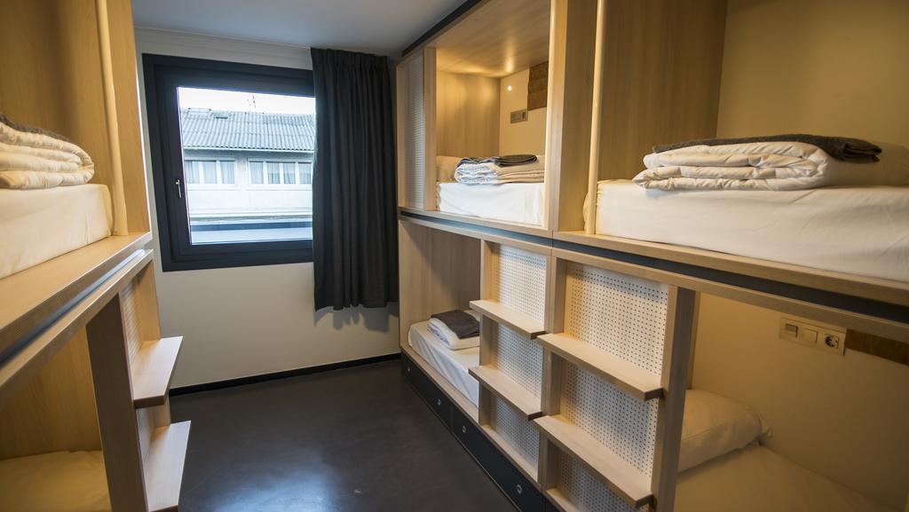 Cama en habitación compartida mixta con 6 camas y baño compartido